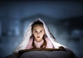 Little girl reading book in bed Royalty Free Stock Photo