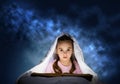 Little girl reading book in bed Royalty Free Stock Photo