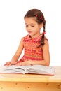 Little girl reading book on the desk Royalty Free Stock Photo