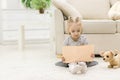 A little girl reading a book on the floor. Royalty Free Stock Photo