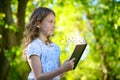 Little girl reading a book and flying letters Royalty Free Stock Photo