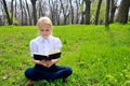 Little girl reading book in the park Royalty Free Stock Photo