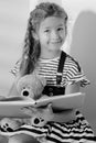 Little girl is reading a book to a teddy bear. Royalty Free Stock Photo