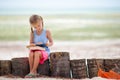 Little adorable girl with book on tropical white beach Royalty Free Stock Photo