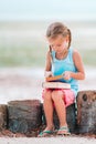 Little adorable girl reading book during tropical white beach Royalty Free Stock Photo