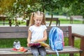 Little girl is reading books in the school park. The concept of school, study, education, friendship, childhood Royalty Free Stock Photo