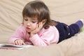 Little girl reading on sofa Royalty Free Stock Photo