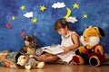 Little girl reading stories to her stuffed toy friends