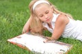 Little girl reads book on the grass Royalty Free Stock Photo