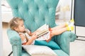 A little girl reads a large heavy book