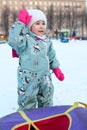 Little girl is ready for riding on snow tubing from slope in city park Royalty Free Stock Photo