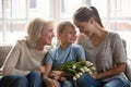 Little girl received from mother and grandmother flowers and gift Royalty Free Stock Photo