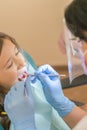 Little girl at the reception in the dentist's office. little girl sitting in a chair near a dentist after dental treatment. Littl Royalty Free Stock Photo