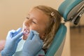 Little girl at the reception in the dentist& x27;s office. little girl sitting in a chair near a dentist after dental treatment. Royalty Free Stock Photo