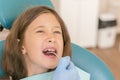 Little girl at the reception in the dentist& x27;s office. little girl sitting in a chair near a dentist after dental treatment. Royalty Free Stock Photo