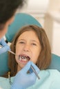 Little girl at the reception in the dentist& x27;s office. little girl sitting in a chair near a dentist after dental treatment. Royalty Free Stock Photo