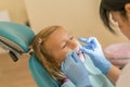 Little girl at the reception in the dentist& x27;s office. little girl sitting in a chair near a dentist after dental treatment. Royalty Free Stock Photo