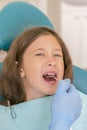 Little girl at the reception in the dentist& x27;s office. little girl sitting in a chair near a dentist after dental treatment. Royalty Free Stock Photo