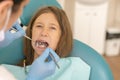 Little girl at the reception in the dentist& x27;s office. little girl sitting in a chair near a dentist after dental treatment. Royalty Free Stock Photo