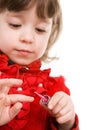 Little girl in red applying polish on nails