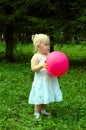 Little girl with red balloon in the forest. Royalty Free Stock Photo