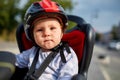 Little girl in red and black helmet seat bicycle in city park Royalty Free Stock Photo