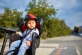 Little girl in red and black helmet seat bicycle in city park Royalty Free Stock Photo