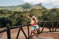 A little girl with a red can of drink in her hands against the background of the mountains of the island of Mauritius, nature