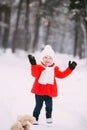 Little girl in red coat with a teddy bear having fun on winter day. girl playing in the snow Royalty Free Stock Photo