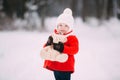 Little girl in red coat with a teddy bear having fun on winter day. girl playing in the snow Royalty Free Stock Photo