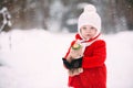 Little girl in red coat with a teddy bear having fun on winter day. girl playing in the snow Royalty Free Stock Photo