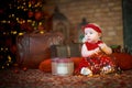 little girl in red dress against background of Christmas tree holds Christmas garland in her hands. baby 6 month old celebrates