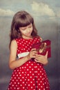 Little girl in red dress holding her present Royalty Free Stock Photo