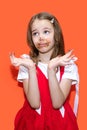 A little girl in a red dress smeared chocolate on her hands and mouth and became upset