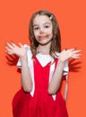 A little girl in a red dress smeared her hands and face with chocolate Royalty Free Stock Photo