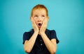 Little girl with red hair in panic puts her hands to face, opened mouth and looks up, expresses fright or puzzled, has Royalty Free Stock Photo