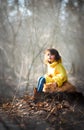 Little girl with red persian cat in the forest. Soft natural light. Cat is looking forward. Girl lay down her hand on cat