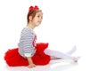 Little girl in a red skirt and bow on her head. Royalty Free Stock Photo