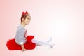 Little girl in a red skirt and bow on her head. Royalty Free Stock Photo