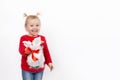 A little girl in a red sweater, blue jeans wishes you a happy holiday! Royalty Free Stock Photo