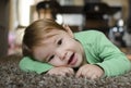 Little girl relaxing on the carpet at her home Royalty Free Stock Photo