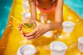 Little girl relaxing in swimming pool, enjoying suntans, drink a juice on inflatable yellow mattress Royalty Free Stock Photo