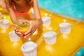 Little girl relaxing in swimming pool, enjoying suntans, drink a juice on inflatable yellow mattress Royalty Free Stock Photo