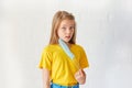 A little girl removes a protective sterile medical mask on a light background. Happy ending. Victory over the coronavirus.