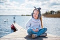 Little girl resting sitting by the river in spring nature Royalty Free Stock Photo