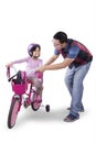 Little girl ride bicycle with dad in studio Royalty Free Stock Photo