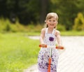 Little girl ride the scooter in the park Royalty Free Stock Photo