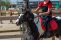 Little girl that rides a brown pony during Pony Game competition at the Equestrian School