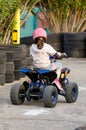 Little Girl Rides a Motorcycle ATV with Four Wheels. Outdoor Activity for Children on an Electric Racing Quad Bike Machine