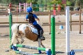 Little Girl that rides a white Pony and Jumps the obstacle during Pony Game competition at the Equestrian School